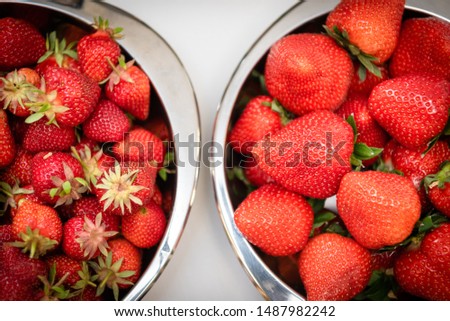 Two bowls of red ripe strawberries