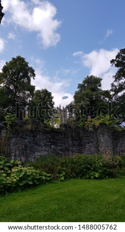 Picture of the sky, wall fence and a tower with Scottish flag.
