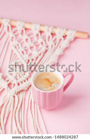 Creative flat lay concept, coffee cup and macrame panel on pastel pink background and copy space, minimal style, saint valentine romance trendy composition