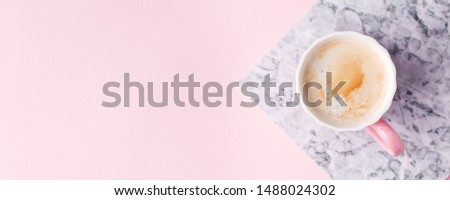 Creative flat lay concept top view of coffee cup on marble plate on pastel pink background and copy space, minimal style, saint valentine romance trendy composition