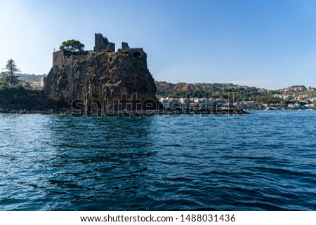 Aci Castello (Sicily Italy) rocks and castle, picture taken offshore from the sea