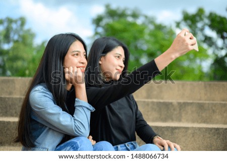 Two young students take a selfie at the university.