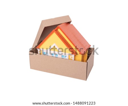 Toy model of a house in a cardboard box on a white background.