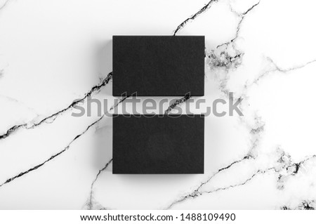 Photo of black business cards on white marble. Template for branding identity isolated on marble background. For graphic designers presentations and portfolios marble premium luxury mock-up.