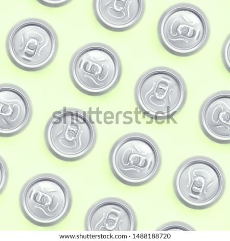 Many metallic beer cans on texture background of fashion pastel lime color paper