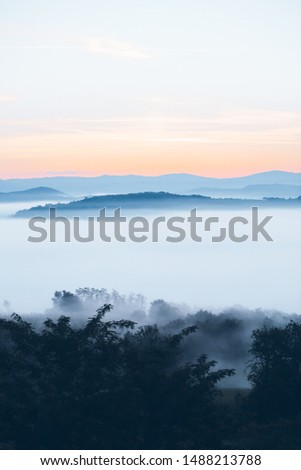 view of sunrise over the mountains mist and clouds under peaks landscape