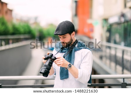 Portrait of happy, smiling man, tourists with camera in the city.