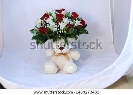 Flower arrangement with teddy bear. 