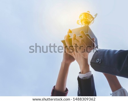 The best team helped each other reach their goals target to success. The hand of a business man and business women pick up the trophy and celebrate together. Teamwork of successful concept Royalty-Free Stock Photo #1488309362