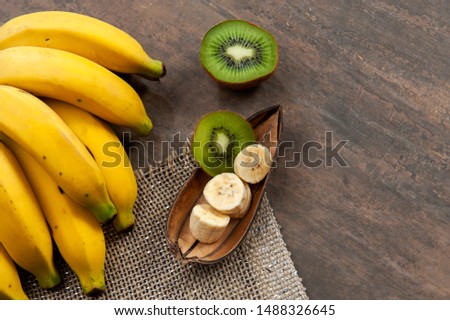 Fruit, banana peel, Kiwi fruit.Half kiwi and chopped bananas.Vitamin C, potassium.Again wood color background.Top view.Top space. Text space. Royalty-Free Stock Photo #1488326645