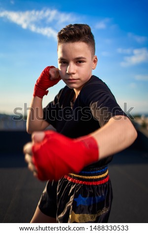 Young muay thai fighter or kickboxer training on the roof above the city