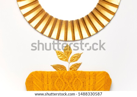 Fashionable vintage modern golden frame, knitted orange sweater, golden autumn leaves isolated on white background. Photo frame, mirror frame, baguette, stylish interior item. Autumn, fall concept