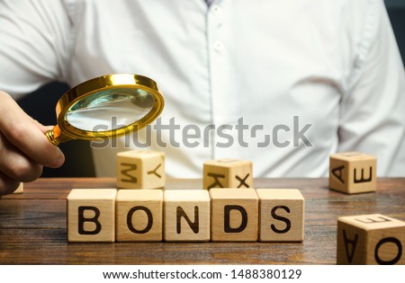 Wooden blocks with the word Bonds and businessman. A bond is a security that indicates that the investor has provided a loan to the issuer. Equivalent loan. Unsecured and secured bonds. Royalty-Free Stock Photo #1488380129