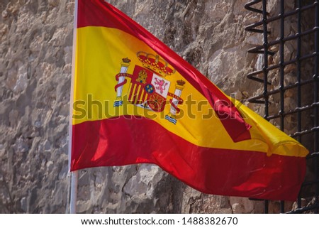 Waving flag of Spain hanging on the Kingdom of Spain institutions and administrative building in Alicante, Valencia, Spain


