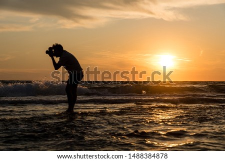 A photographer taking a picture during the sunset in the sea, Preveza, Greece