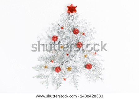 Christmas composition. Christmas tree made of conifer branches, red balls, golden decorations on white background.