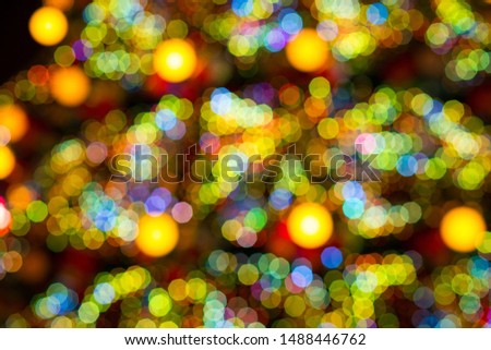 City Christmas tree in the evening. Christmas background with bokeh from light bulbs. Defocused christmas tree silhouette with blurred lights