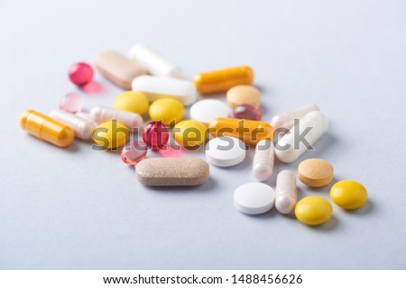 Vitamins and supplements on bright paper background. Concept for a healthy dietary supplementation. Close up. Copy space.  Royalty-Free Stock Photo #1488456626
