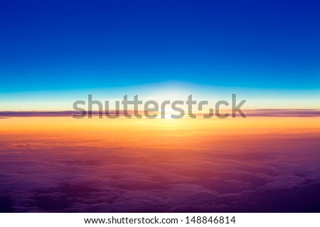 sunset with a height of 10 000 km. Dramatic sunset. View of sunset above clouds from airplane window Royalty-Free Stock Photo #148846814