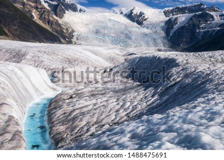 Glacier stream on the root glacier with stairway icefall in the background in Wrangell-St. Elias National Park Alaska. 