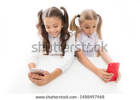 Phones designed for learning. Small kids having video lesson on mobile phones. Little girls using camera in their phones. Cell phones are educational tools in classroom.