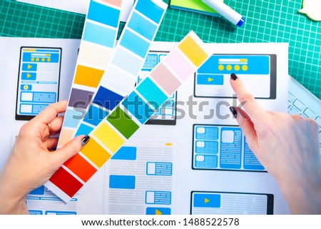 Mobile application design development. Select the color scheme for the program. Mobile application designer at work. Development of design project of additional programs for electronic gadgets.