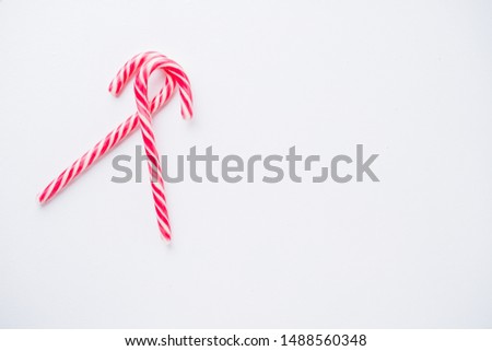 Christmas poster template, white background with festive candies and copy space. Creative minimalistic greeting card. Winter holidays celebration concept