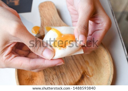 Hand squeezing Creamy custard bun baozi in restaurant