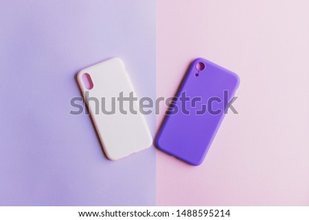 Two silicone cases on purple and pink backgrounds. Pastel pink and purple silicone smartphone cases. Colorful silicone cases for your mobile phone. The covers are heart-shaped. Valentine's day.