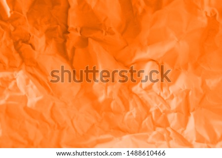 Wrinkled orange paper fragment as a background texture.