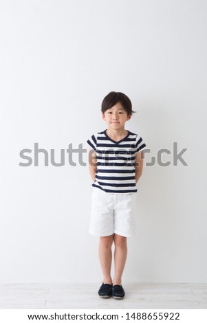 Portrait of elementary school student in front of white wall