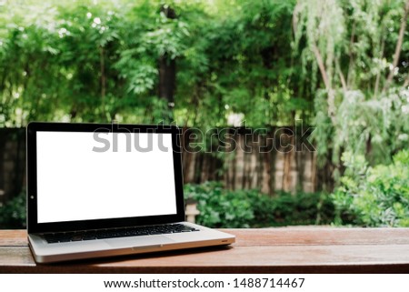 Mock up laptop.Laptop computer on wooden table in the garden.