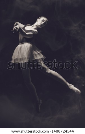 A full length portrait of an elegant refined ballet female dancer posing in the studio over the black background. Talent, fashion for ballet dancers. 