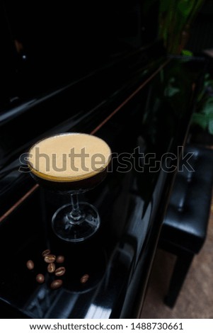 "Espresso Martini" new menu by using double shot of espresso with syrup and shake serving glass on the black classic piano