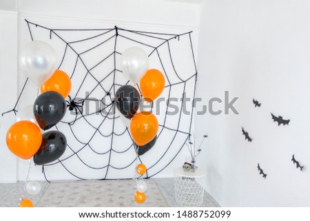 Halloween background with spider web and orange balloon in white room