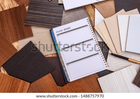 Notepad and pen with wooden swatch on table