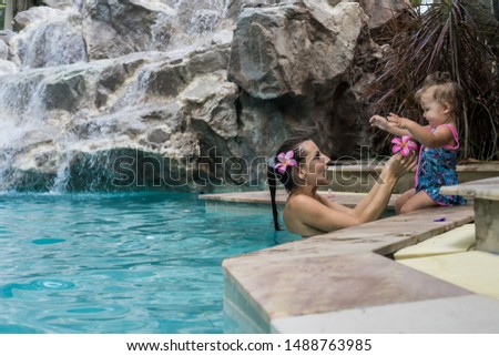 Mom and Daughter in the pool. Smiling beautiful women and her little cute daughter on the poolSummer vacation, holiday and tourism concept. Copy space