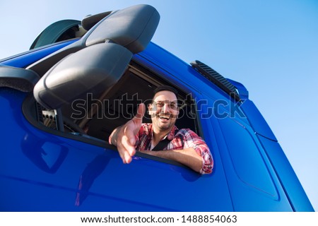 Truck drivers job openings. Truck driving careers. Middle aged professional trucker driver sitting in his vehicle cabin and giving a shaking hand to new recruits. Drivers wanted. Royalty-Free Stock Photo #1488854063