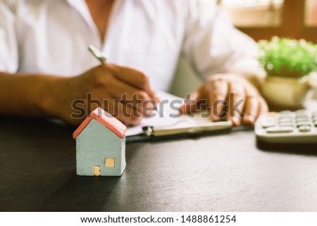Businessman with Home insurance contract and calculator.