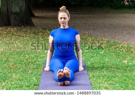 White girl in a city park in the morning doing yoga