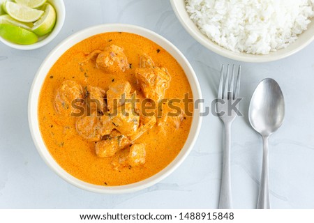 Traditional Indian Butter Chicken with Rice Top View Photo. Creamy Indian Chicken Curry on White Background. Royalty-Free Stock Photo #1488915848