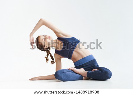 woman in lollipops in a short T-shirt go in for sports on a light floor, yoga asanas