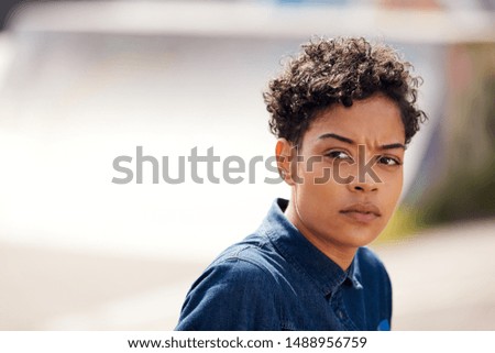 Outdoor Head And Shoulders Portrait Of Young Woman In Urban Skate Park