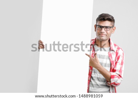 Handsome Indian/Asian Male college student showing blank signboard 