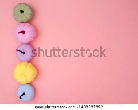 Creative autumn background. Top view of hand-painted various colors pumpkins on pink background. Autumn forest stuff. Minimalist style Fall or Thanksgiving decorative border, frame.