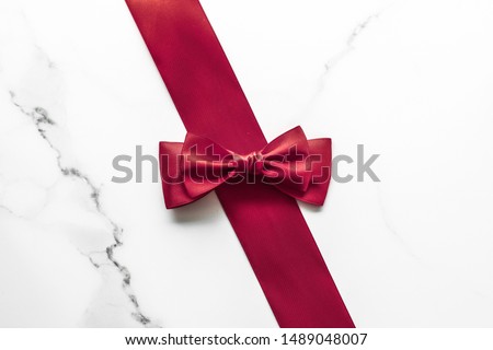 Holiday gift, decoration and sale promotion concept - Bordeaux silk ribbon on marble background, flatlay Royalty-Free Stock Photo #1489048007