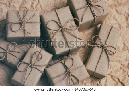 Many parcels wrapped in brown craft paper and tie hemp string. Crumpled background. Presents set. Delivery parcels. 