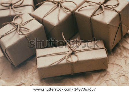 Many parcels wrapped in brown craft paper and tie hemp string. Crumpled background. Presents set. Delivery parcels. 