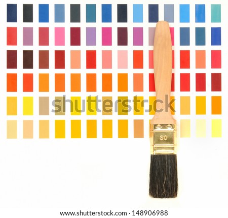 Wooden paint brush in front of a color chart