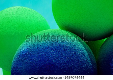 Green and blue balls balloons on cloud sky background. Macro close up image. Vivid holiday poster with copy space. Sunny happy day concept